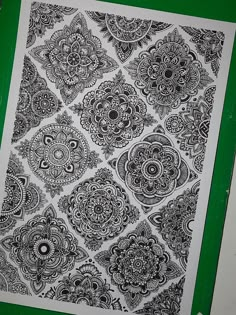 a black and white drawing on a green background with an intricate design in the middle