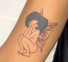 a woman's arm with a tattoo of a fairy sitting on the ground and holding her hand up to her face