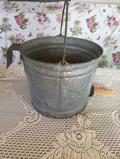 an old metal bucket sitting on top of a table