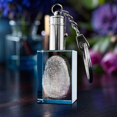 a glass bottle with a key chain attached to it and a fingerprint on the front