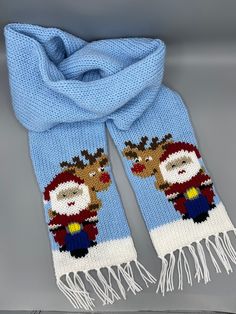 a knitted scarf with reindeers on it and a blue blanket over the top