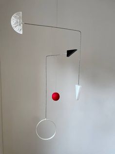 a white room with some red balls hanging from it's ceiling and other objects on the wall