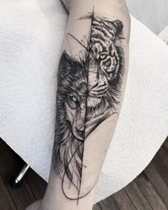 a black and white tattoo on the leg of a person with a tiger behind it