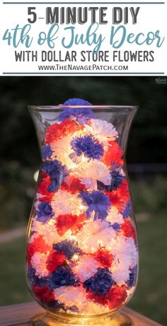 a vase filled with red, white and blue flowers on top of a wooden table