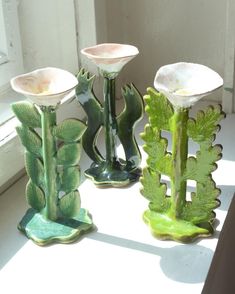 three green vases sitting on top of a window sill next to each other