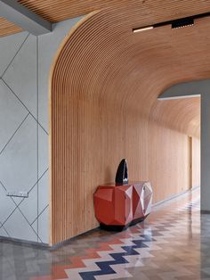 an artisticly designed hallway with geometric patterns and wood paneling on the walls, along with a red cabinet