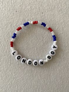 a bracelet with the word london written in white and red beads on top of it