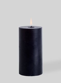 a black candle is lit on a gray background