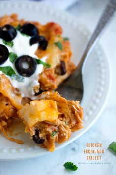 a slice of mexican casserole with black olives and sour cream