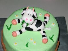 a cake decorated with a cow laying on it's back