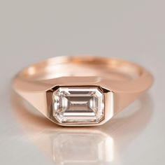 an emerald cut diamond set in a rose gold ring