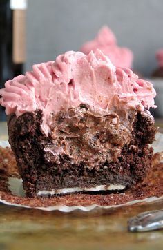 a piece of chocolate cupcake with pink frosting