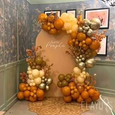 an orange and gold balloon arch in the corner of a room