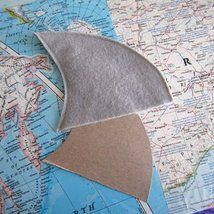 a piece of felt sitting on top of a map with the shape of an airplane