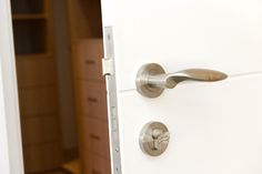 an open door with two knobs on each side and a drawer in the background