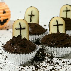 chocolate cupcakes with white frosting decorated like crosses