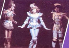 three women in costume standing on stage with one holding her hand out to the side