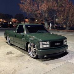 a green pick up truck parked on the street