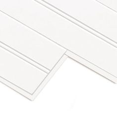 two pieces of white paper sitting next to each other on top of a white surface