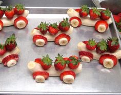 some bananas and strawberries are arranged in the shape of a train on a baking sheet