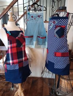 two mannequins dressed in blue and red plaid dresses on display at a shop