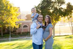 a man, woman and child are standing in the grass