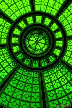 the inside of a green glass structure with circles and dots on it's sides