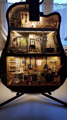 a guitar shaped display case sitting on top of a table