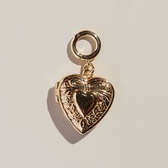 This stunning heart locket is crafted with a gleaming gold finish. With its elegant design, this locket is sure to compliment your look for any occasion. *Add this to our Paper Clip Chain Necklace or Bracelet. Or spice your ear stack up and add it to your favorite pair of Pave Huggies or Halo Hoops! Paper Clip Chain Necklace, Safety Pin Jewelry, Nickel And Suede, Luxe Jewelry, Ear Stack, Birthstone Earring, Pin Jewelry, Heart Locket, Small Heart