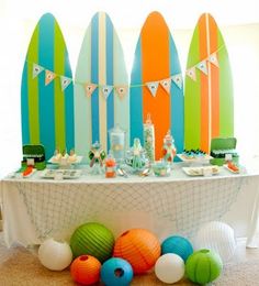 a surfboard themed birthday party is set up on a table