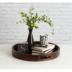 a wooden tray with books and a vase on it