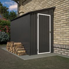 a small shed sitting next to a pile of firewood in front of a brick building