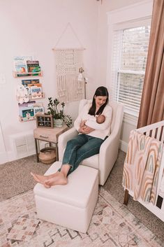 a woman sitting in a chair holding a baby