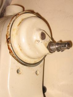 an old white sink with rust on the rim and water faucet attached to it