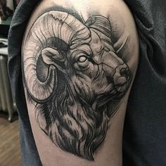 a black and white photo of a ram tattoo