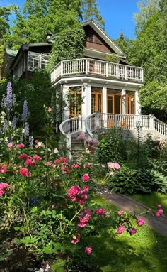 a house surrounded by lush green trees and flowers