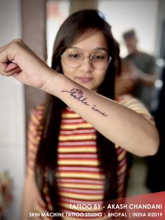 a woman with a small tattoo on her arm and the word love is written in cursive writing