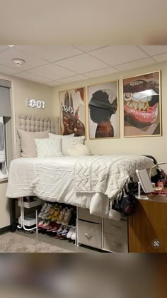 a bed sitting in a bedroom next to two pictures on the side of a wall