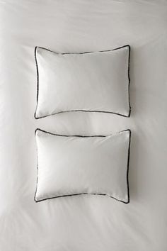 two black and white pillows on a bed