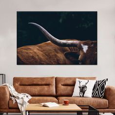 a living room with a couch, coffee table and cow's head on the wall