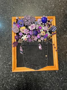 a pair of jeans with buttons and flowers in the back pocket are displayed on a table