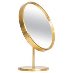 a round mirror sitting on top of a metal stand