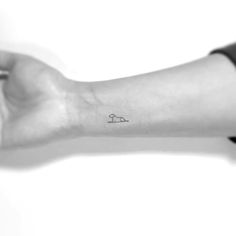 a person's arm with a small dog tattoo on the left side of their arm