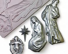 a set of three metal castings including a nativity scene, and an ornament