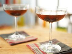 two glasses of wine sitting on top of a wooden table next to eachother