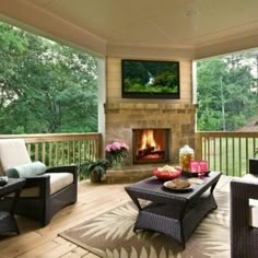 an outdoor living area with wicker furniture and a television mounted above the fire place