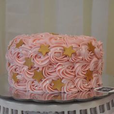 a pink cake with gold stars on top