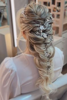 a woman is sitting in a chair with her hair styled into a half - up braid