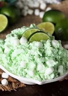 a bowl filled with marshmallow and limes