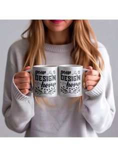 a woman holding two coffee mugs with the words your design is me on them